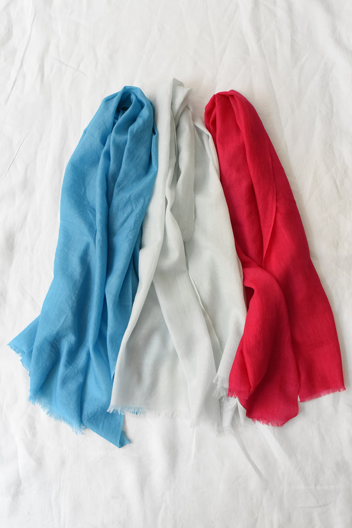 Soft draped cashmere scarves in muted neutral tones with subtle texture