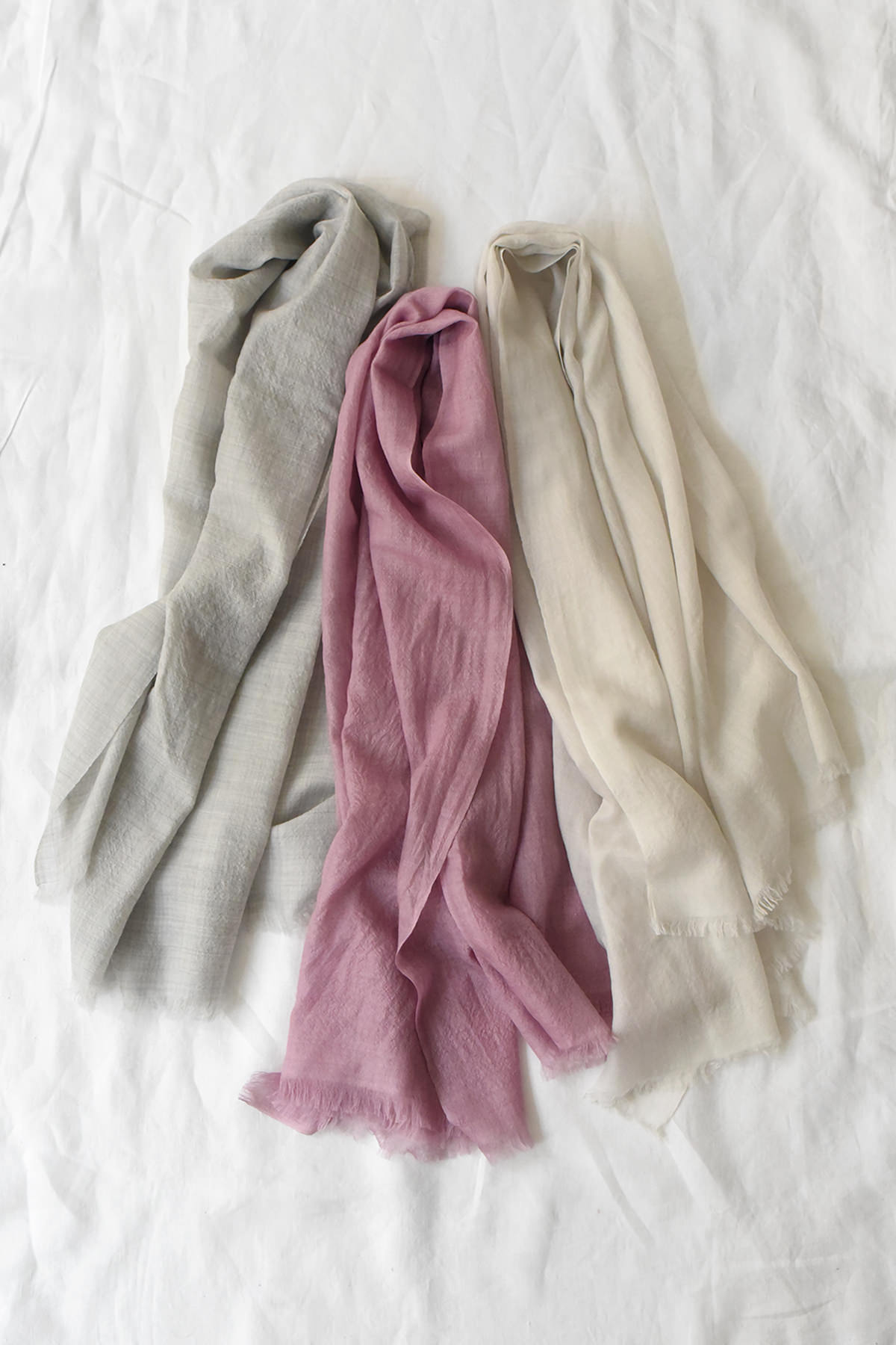 Soft airy cashmere scarves in pale gray, pink mauve, and warm cream tones