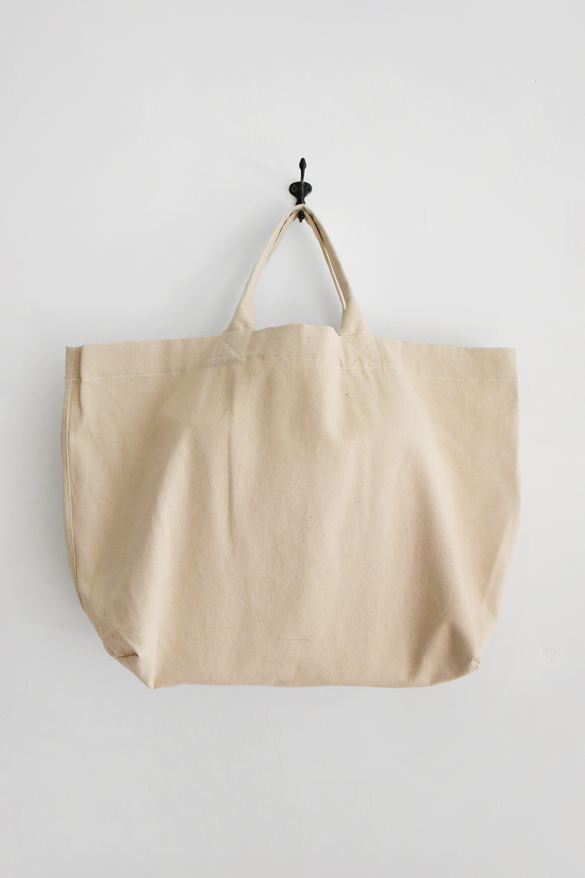 Natural canvas tote bag by MAKIE with wide handles and a simple minimalist design.