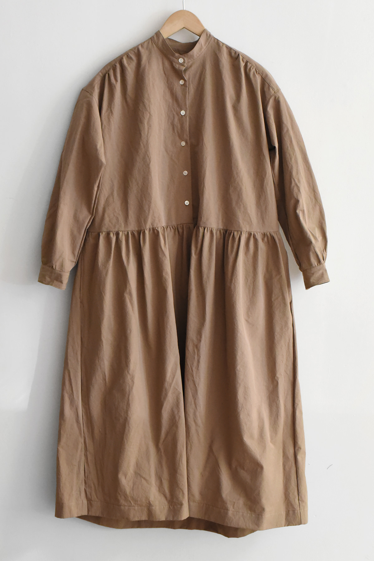 Organic cotton dress with stand collar and long sleeves in beige, gathered waist, minimalist design, made in USA