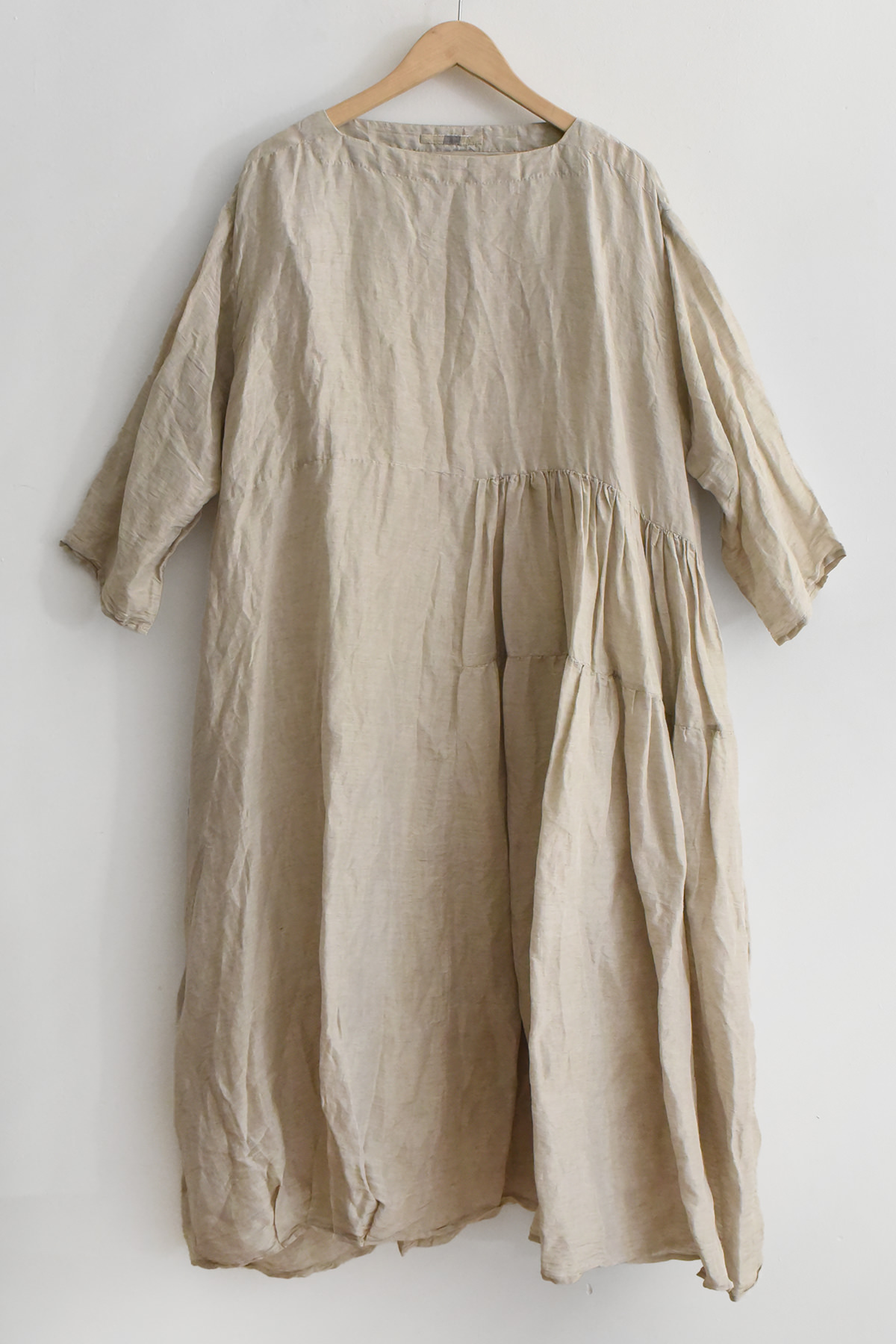 Aodress silk linen dress in natural beige with asymmetrical pleated panel, side pockets, smock hem, and subtle back embroidery