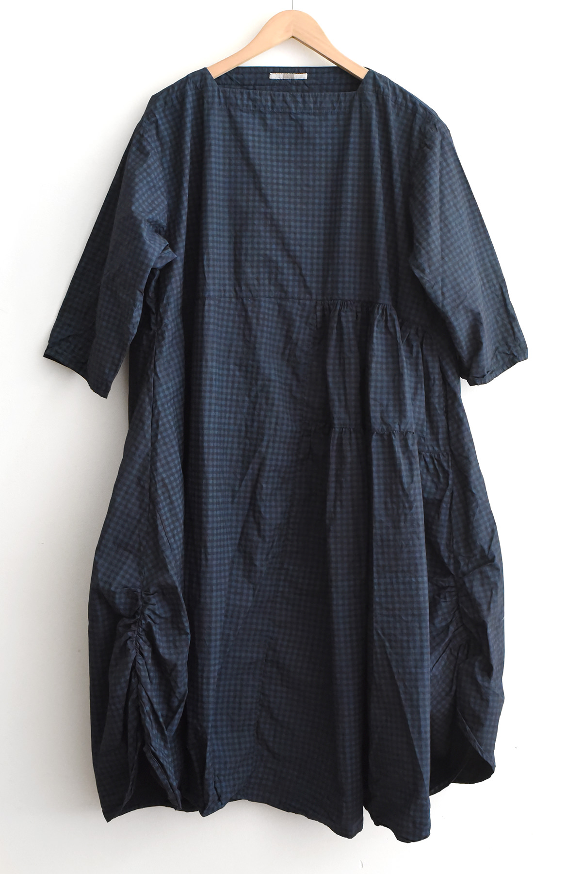 Aodress navy check cotton dress with asymmetrical pleated panel, side pockets, smock-style hem, and relaxed sleeves