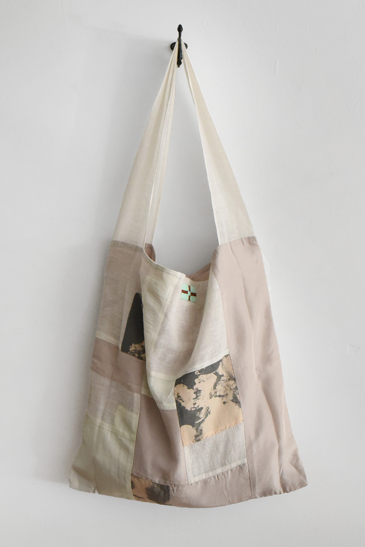 Aodress patchwork shoulder bag in silk, cotton, and linen with natural, blush, ivory, and charcoal fabric panels