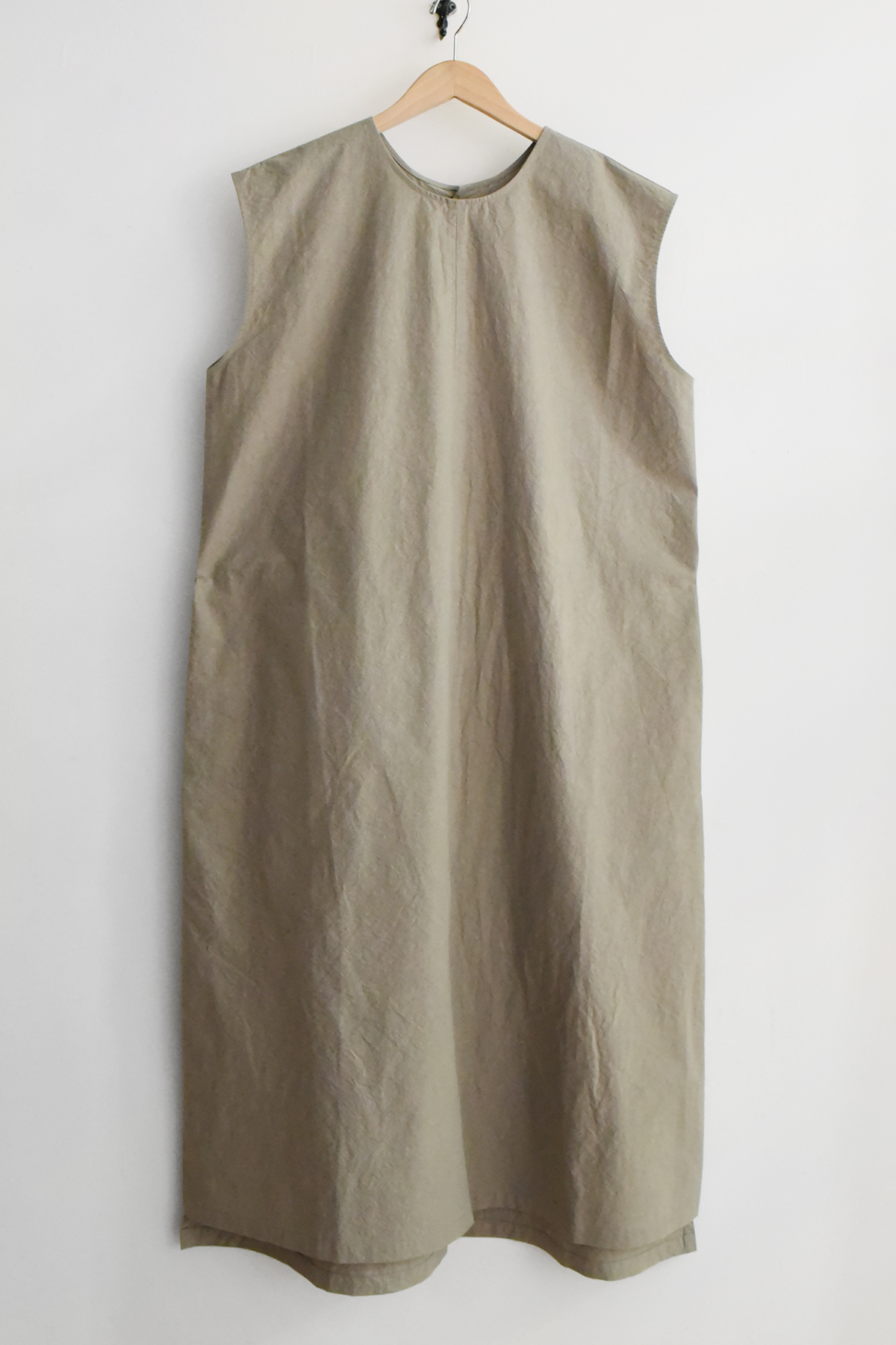 Minimal sleeveless beige dress with front slit and back button closure