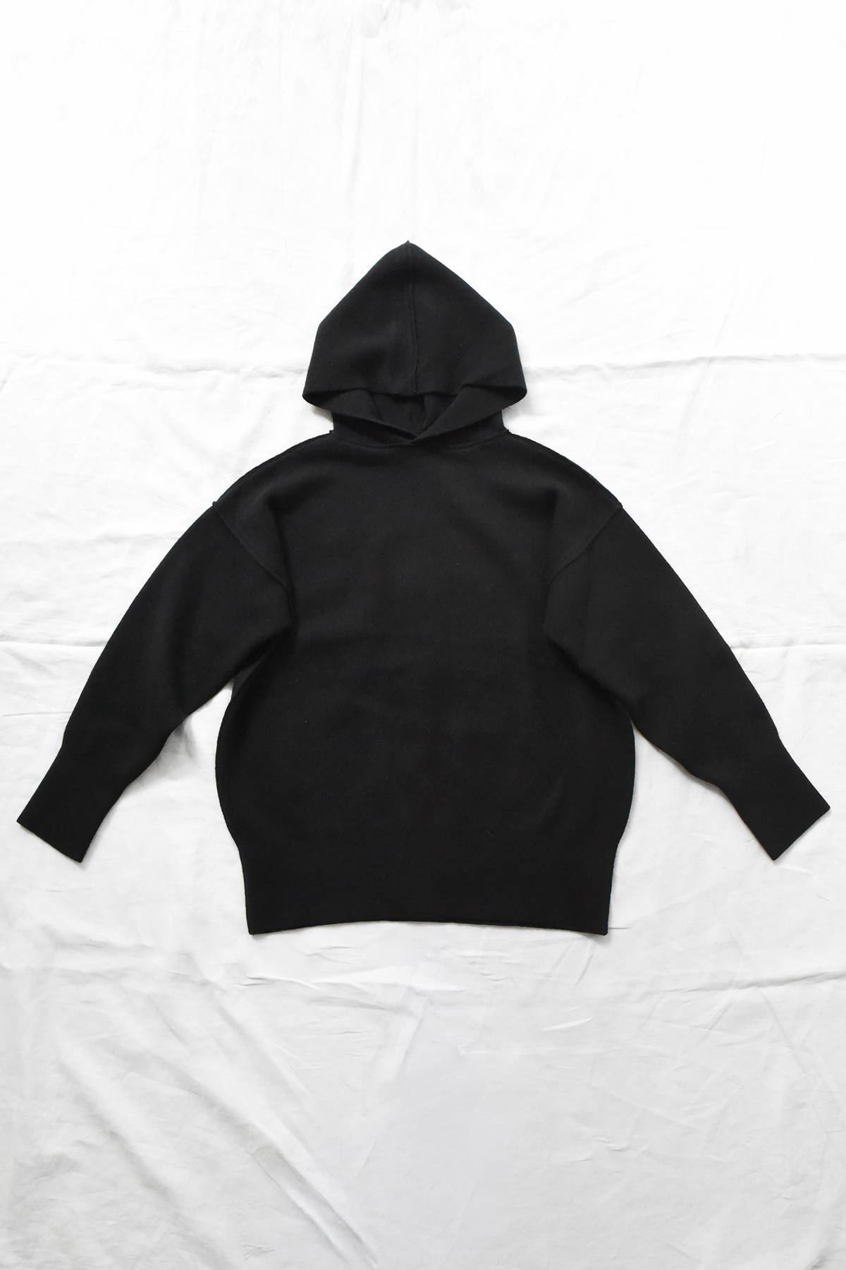 Oyuna reversible cashmere hoodie in Black with sculptural hood and relaxed silhouette