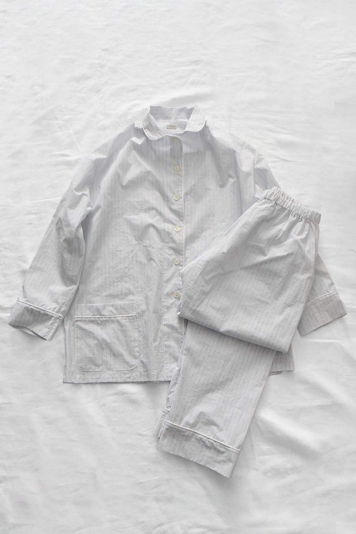 Women's gray pinstripe cotton linen pajama set with button-front shirt and elastic waist pants.