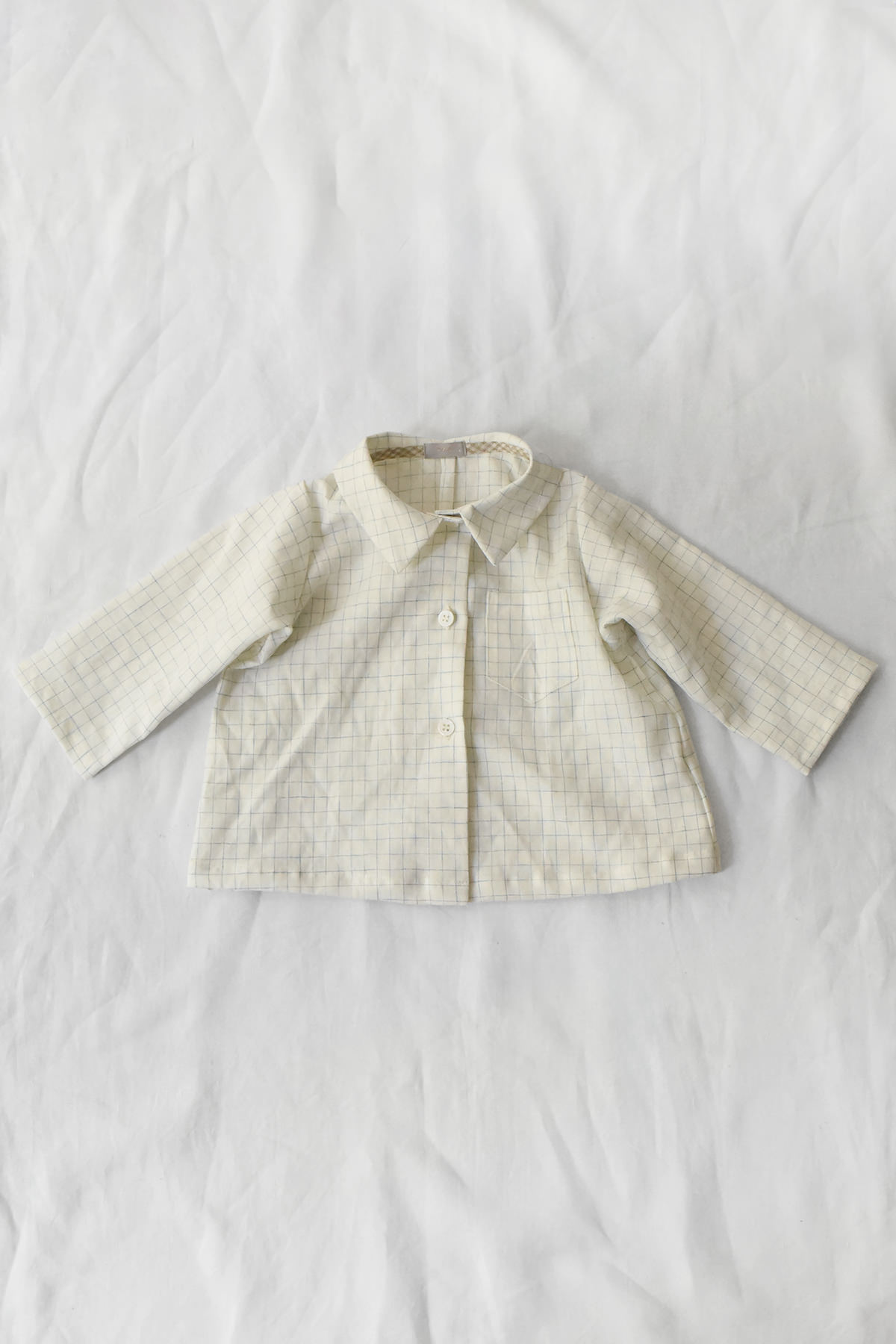 Children's cotton blouse with checked pattern, chest pocket, and button-front closure.