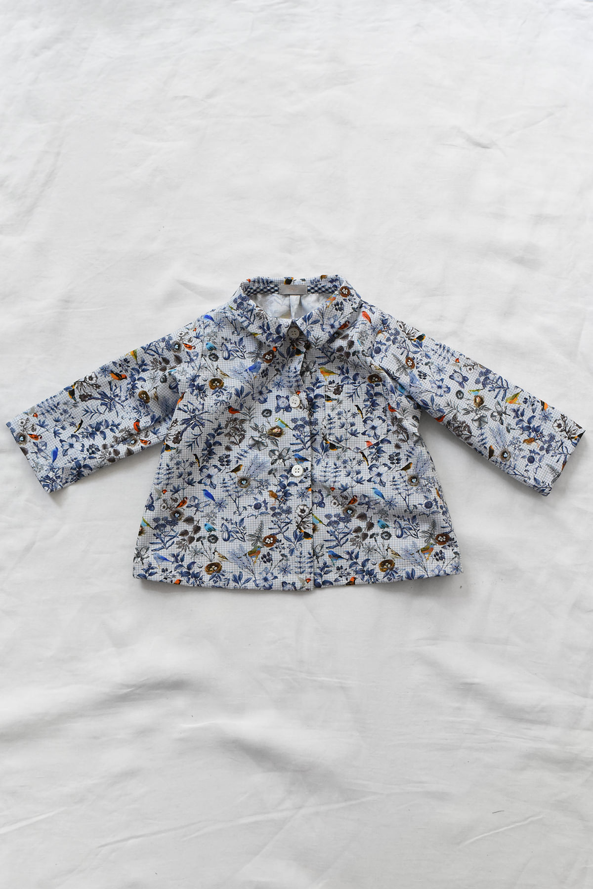 Children's cotton blouse with checked pattern, chest pocket, and button-front closure.