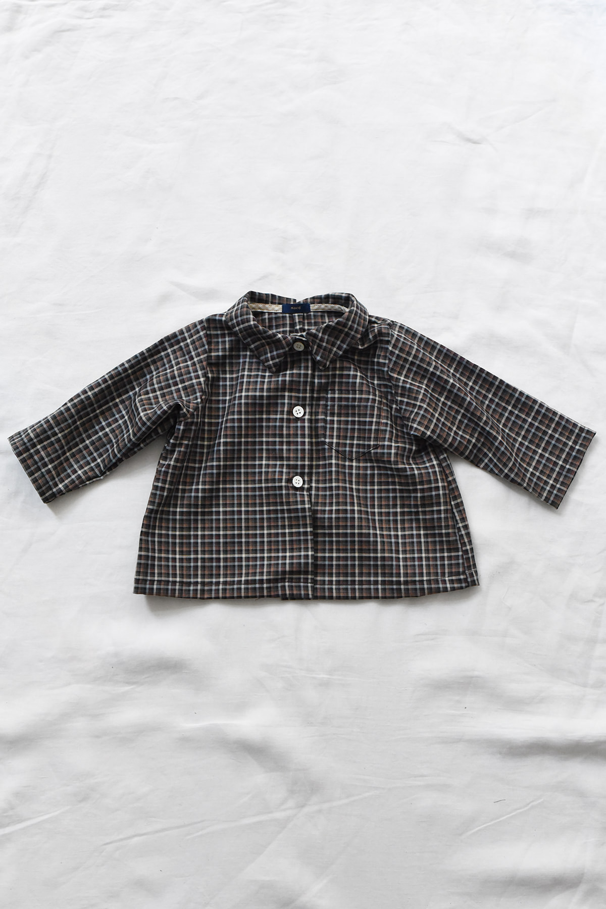 Children's cotton blouse with checked pattern, chest pocket, and button-front closure.