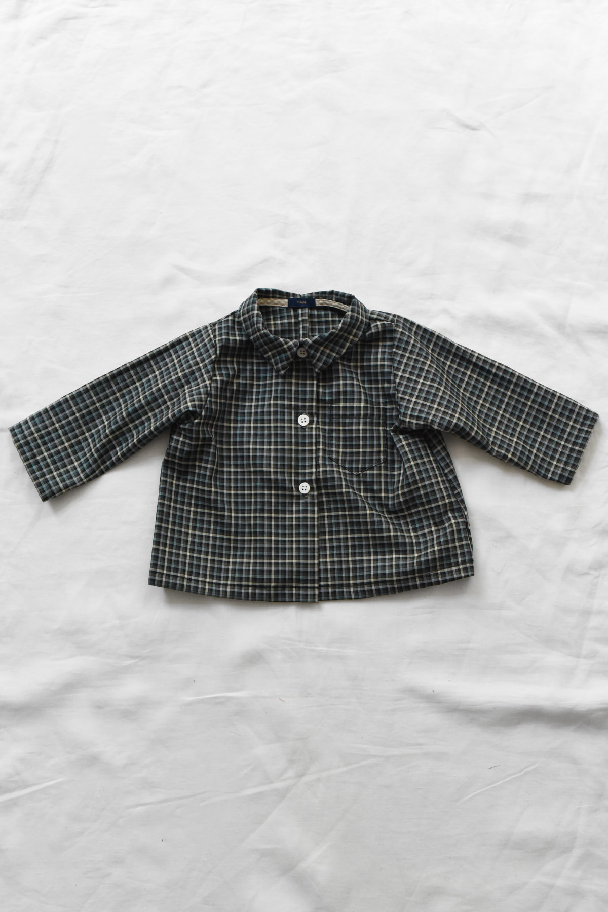 Children's cotton blouse with checked pattern, chest pocket, and button-front closure.