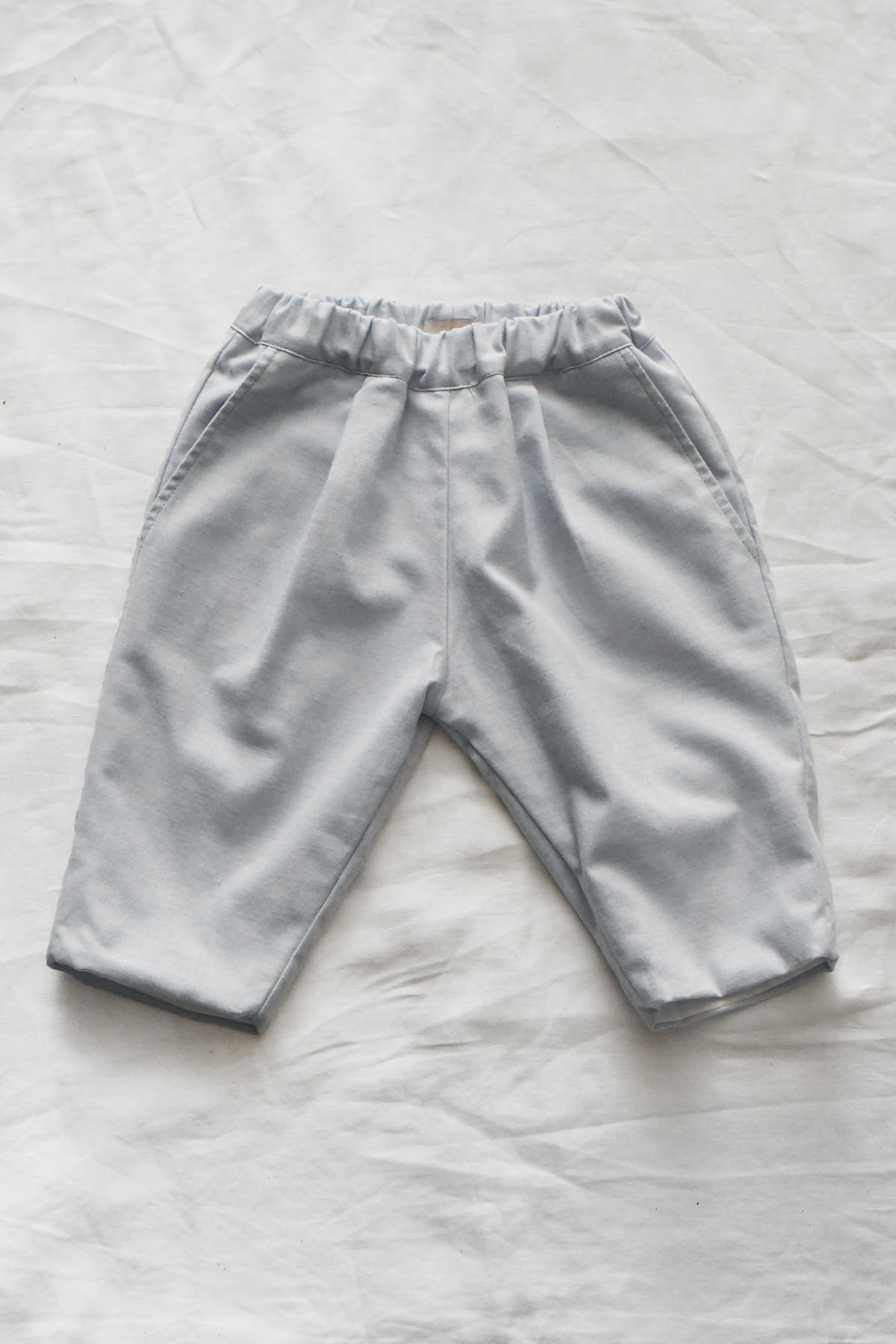 Kids cotton pants with elastic waistband, side pockets, and back pocket.