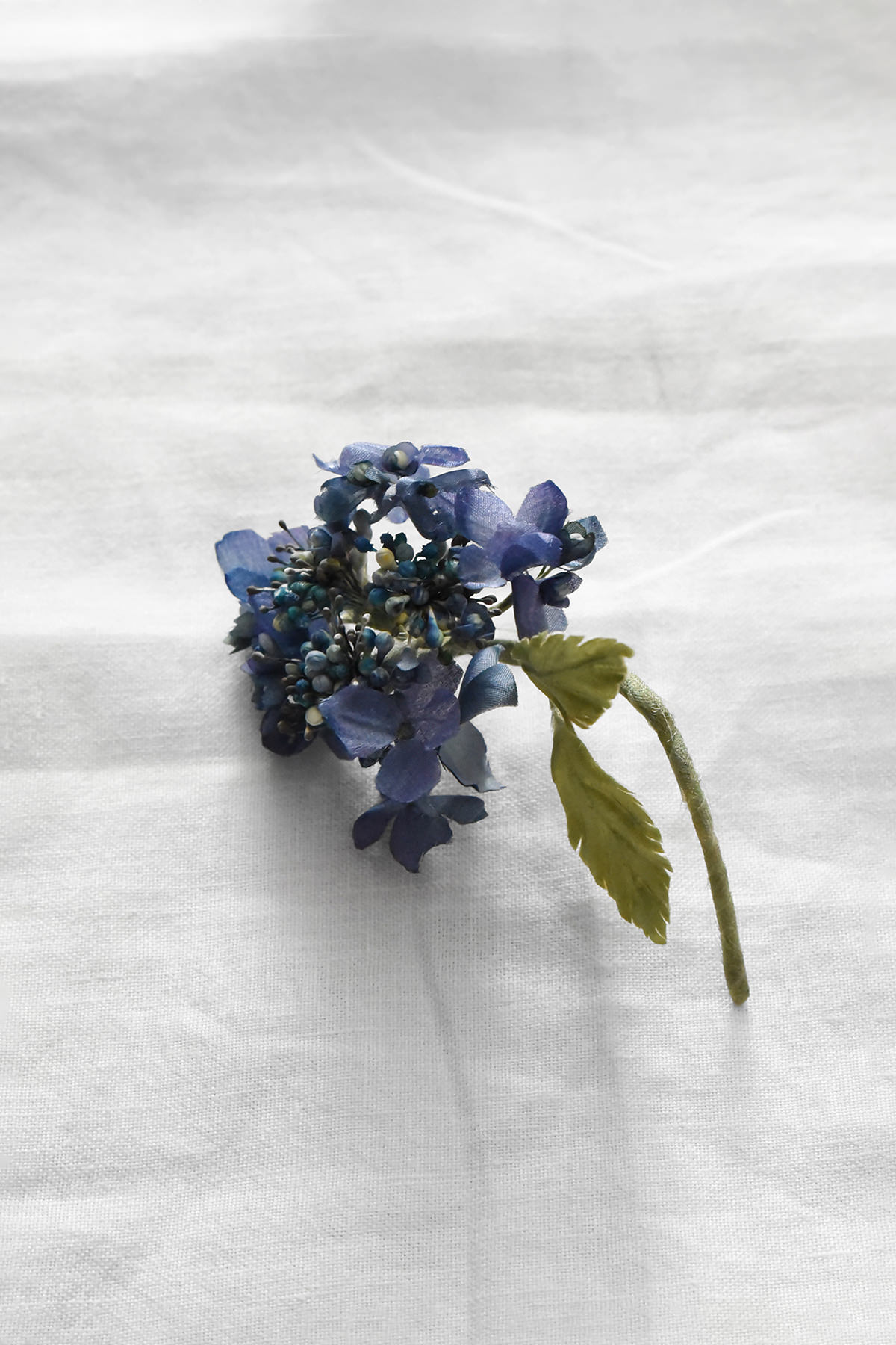 Hand-painted silk hydrangea artwork by Japanese artist Hitoyo with individually painted blue petals and green leaves