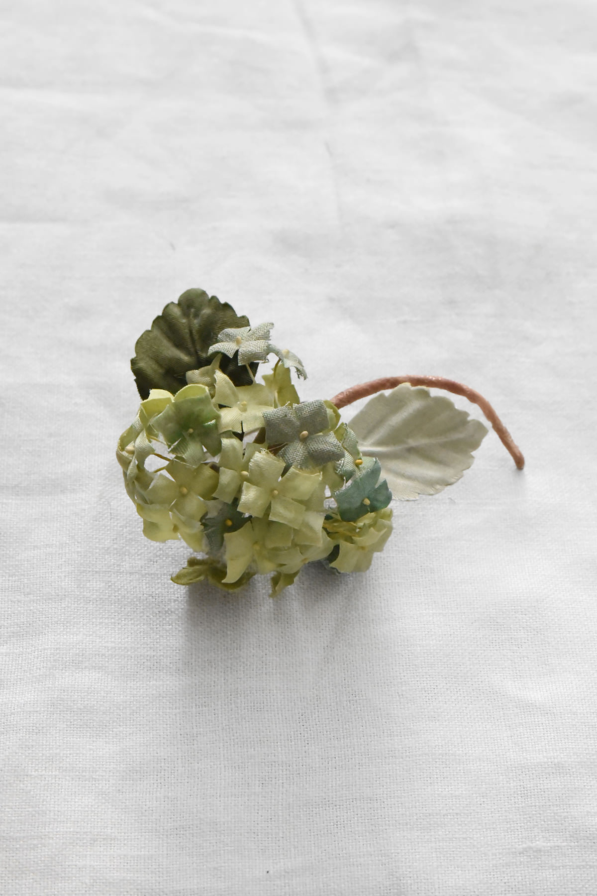 Miniature hand-painted silk hydrangea corsage by Japanese artist Hitoyo with pale green and blue blossoms