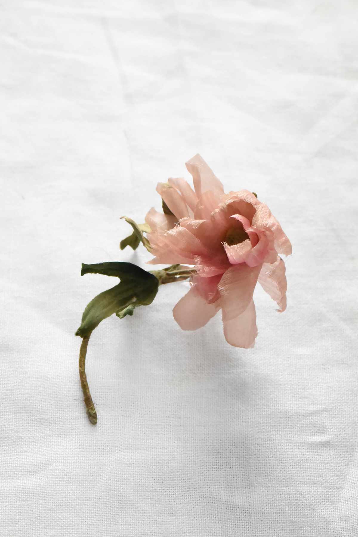 Hand-painted silk anemone flower corsage by Japanese artist Hitoyo with soft pink petals and sculpted green leaves