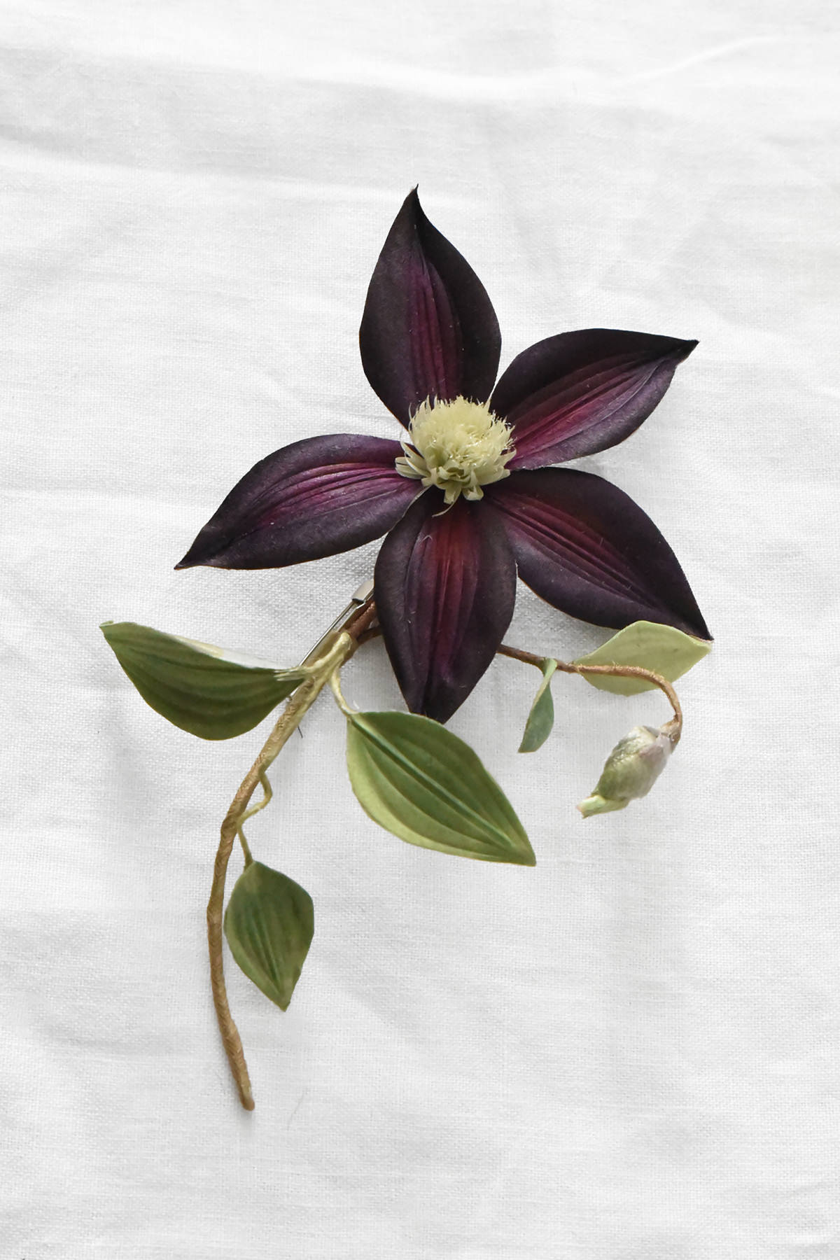 Hand-painted silk clematis corsage with deep purple petals, green leaves, and flower bud by Japanese artist Hitoyo