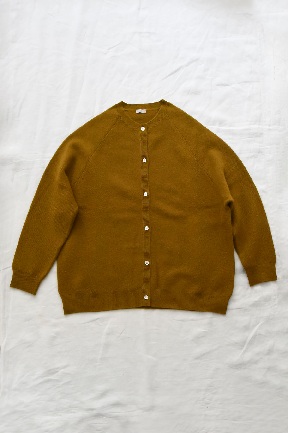 Women's mustard cashmere raglan cardigan with crew neck, front button closure, and ribbed trims