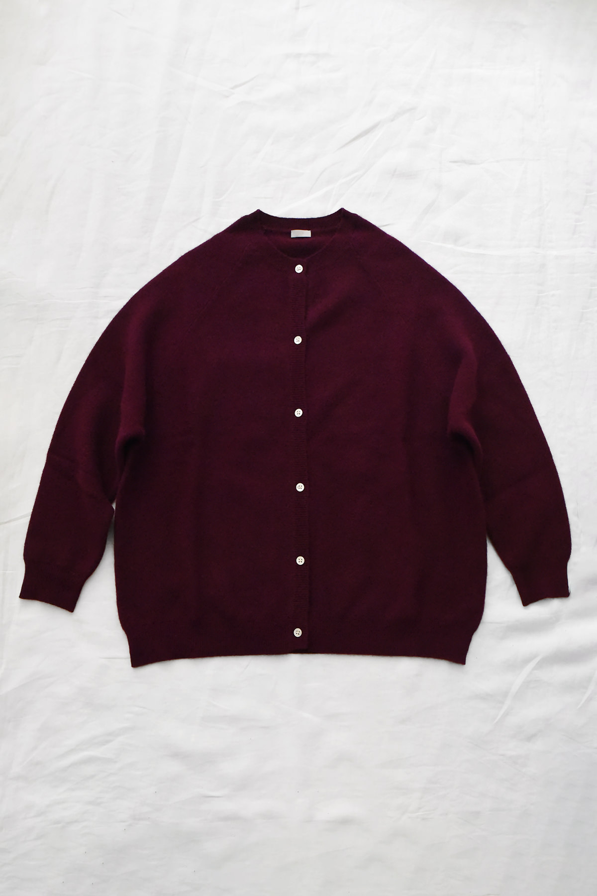 Women's burgundy cashmere raglan cardigan with crew neck, front button closure, and ribbed trims