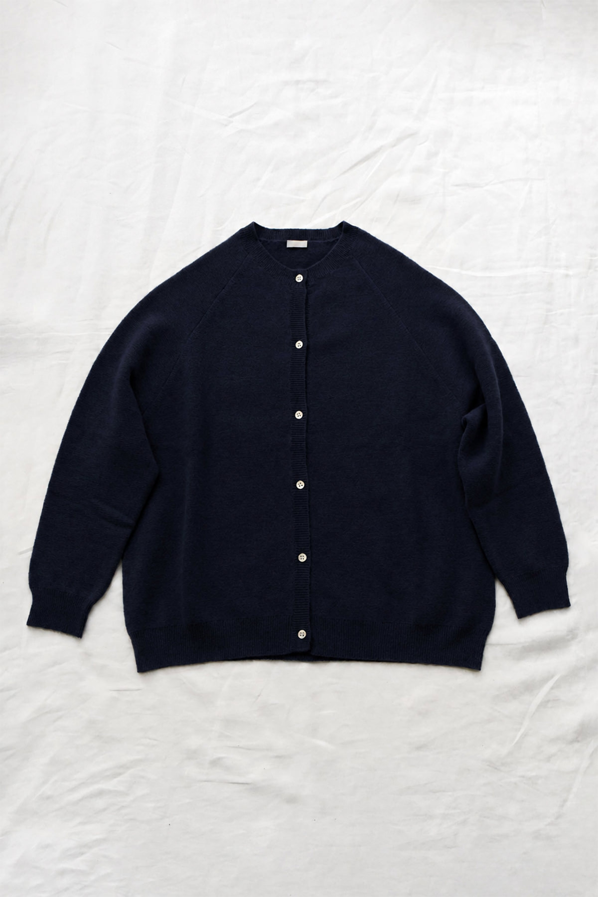 Women's navy cashmere raglan cardigan with crew neck, front button closure, and ribbed trims