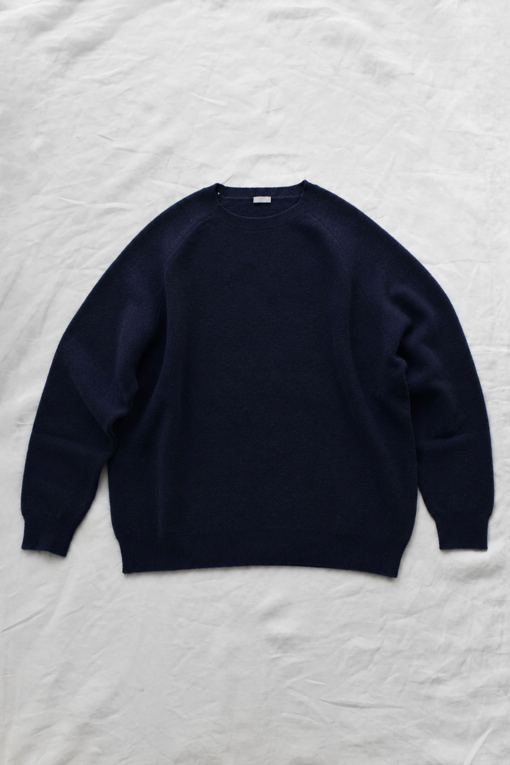 Women's navy cashmere back button sweater with raglan sleeves and crew neck