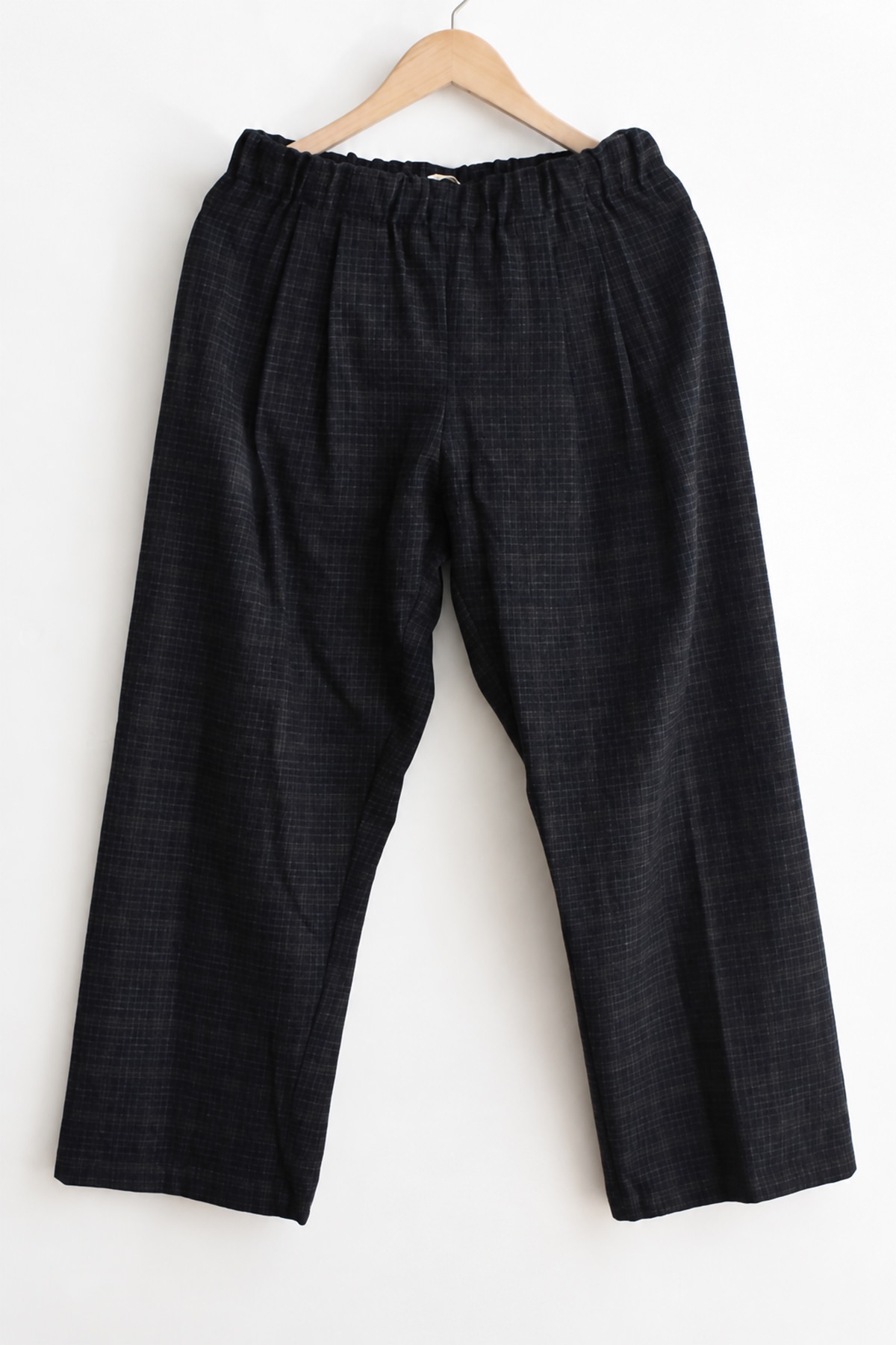 Apuntob (a.b) P1382 Trousers - Blue Military in dark blue with a faint grid pattern and an elastic waistband, hanging on a wooden hanger.